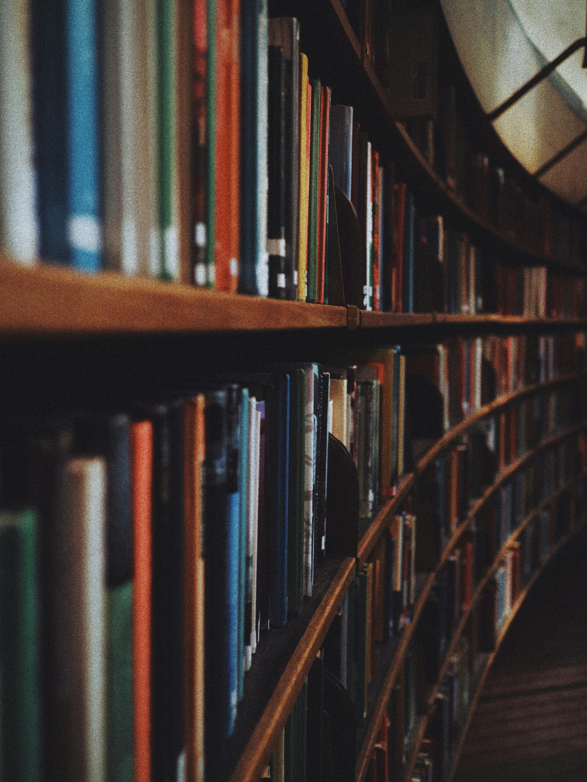 Warm-toned image of curved library bookshelves filled with books in Stockholm.